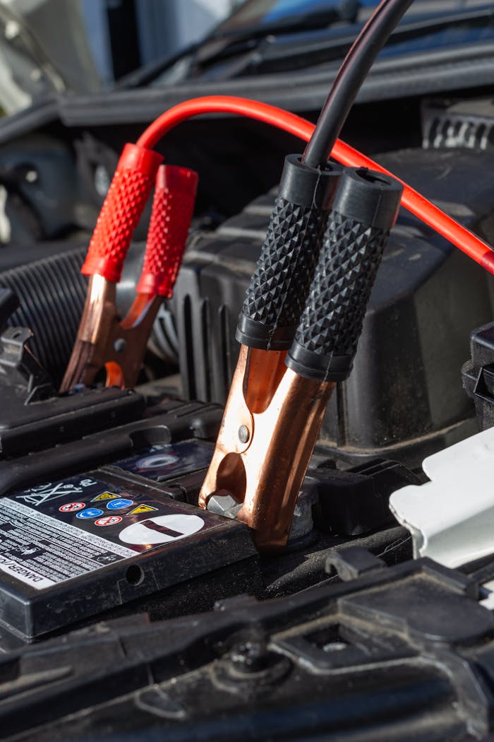 Close-up view of jumper cables charging a car battery.